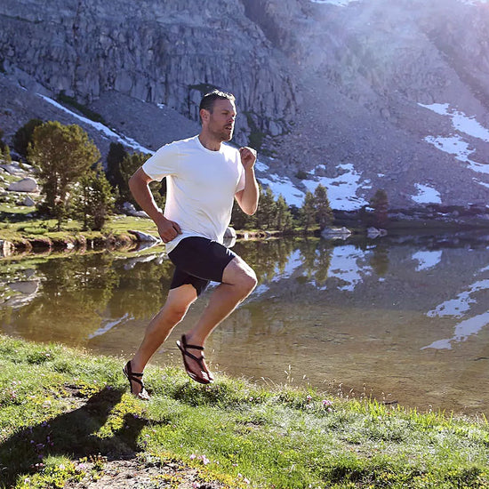 A runner wearing Shamma Warriors while running near a mountainside.
