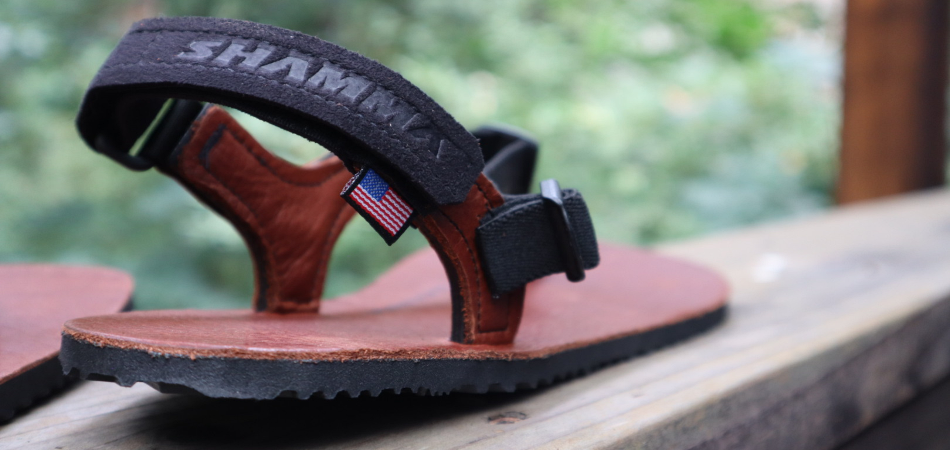 close up of a numa slip-on barefoot sandals with an American flag tag and the Shamma brand on the heel strap