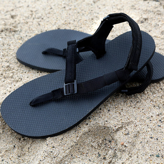 Black Chargers sandals on sand